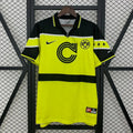 Borussia Dortmund retro short-sleeve jersey, front view with neon yellow body, dark shoulders and sleeves, fold-over collar and BVB 09 crest.
