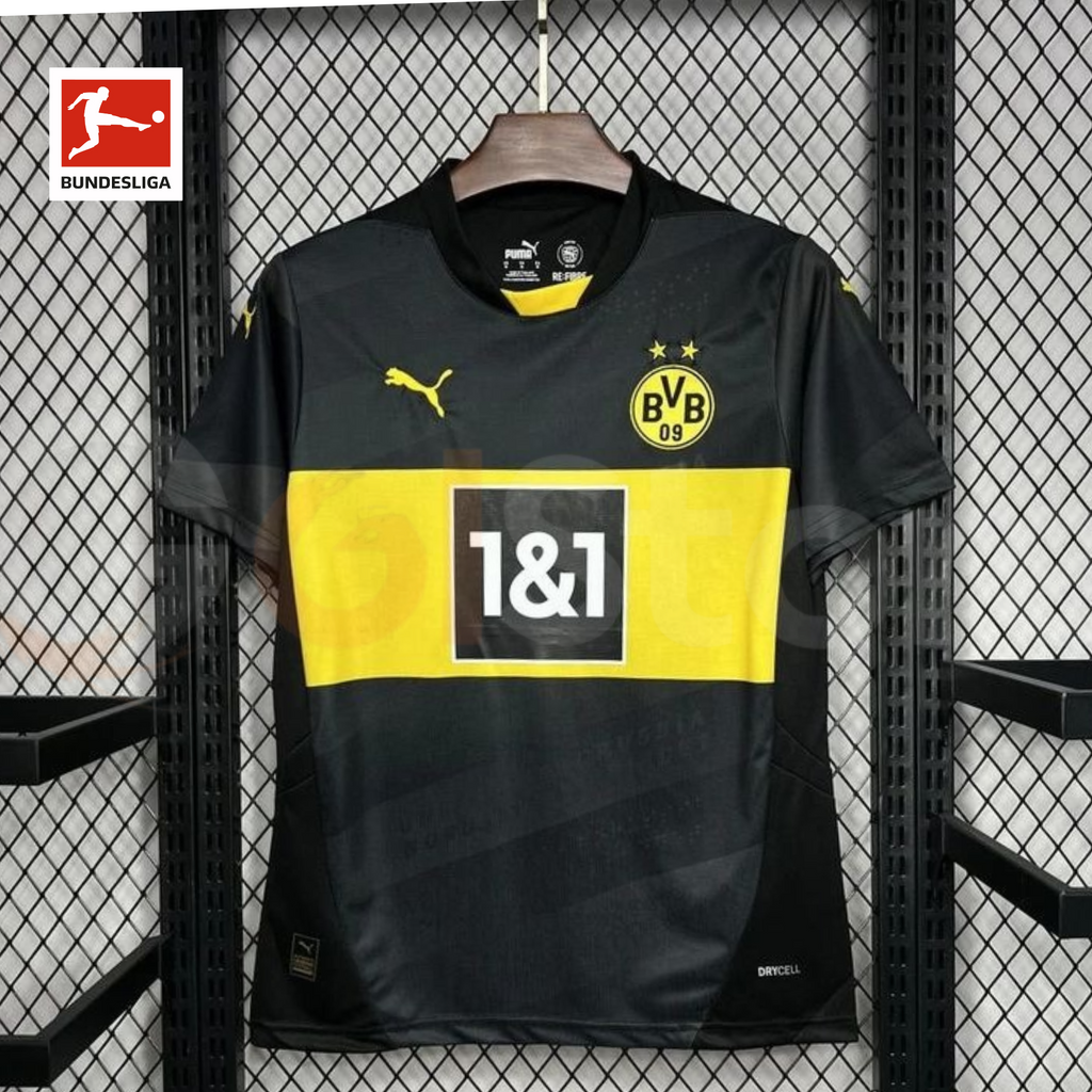 Borussia Dortmund black short-sleeve jersey with a yellow chest band, 1&1 sponsor, yellow BVB crest and Puma logo, alongside a Bundesliga logo graphic.
