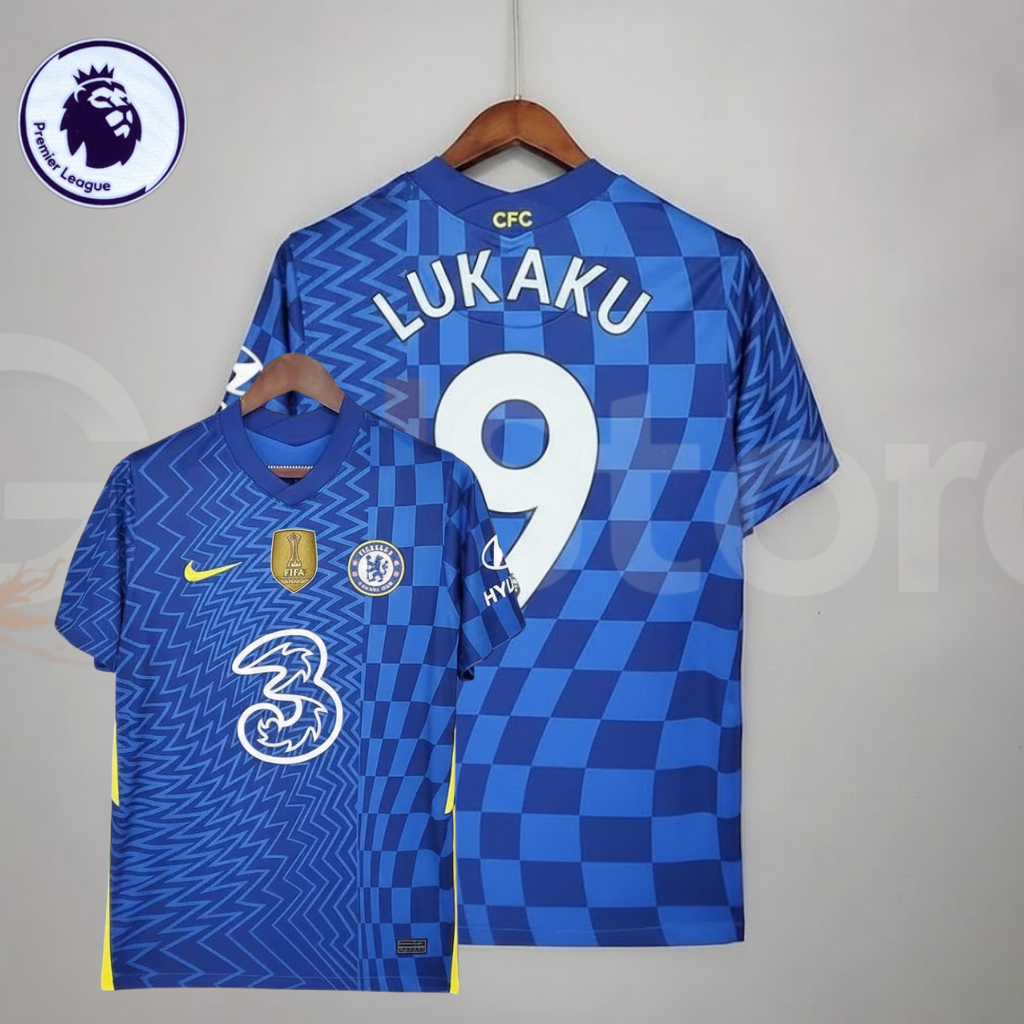 Front and back views of a blue Chelsea FC 2021–2022 short-sleeve home jersey with white Lukaku #9 printing, zigzag and checkerboard patterns, yellow accents and a gold FIFA chest badge.