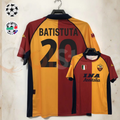 Front and back views of a burgundy and gold AS Roma short-sleeve retro jersey with black Batistuta number 20 print and INA Assitalia sponsor, alongside UCL and Serie A badge graphics.