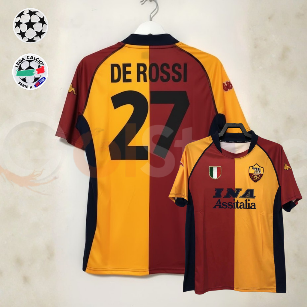 Front and back views of a burgundy and gold AS Roma short-sleeve retro jersey with black De Rossi number 27 print and INA Assitalia sponsor, alongside UCL and Serie A badge graphics.