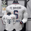 Front and back views of a white Bayern Munich long-sleeve jersey with a dark collar, red and dark sleeve detailing and Kimmich number 6 print, alongside UCL and Bundesliga patch graphics.