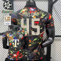  Front and back views of a black Bayern Munich short-sleeve jersey with a multicolored abstract print, cream Pavlovic number 45 lettering and Telekom sponsor, alongside UCL and Bundesliga graphics.