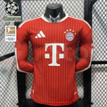 Front view of a red Bayern Munich long-sleeve home jersey with tonal vertical stripes, white shoulder details and Telekom sponsor, alongside UCL and Bundesliga badge graphics.