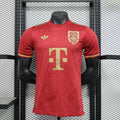 Front view of a red Bayern Munich 125th anniversary short-sleeve jersey with a gold anniversary crest, gold sponsor logo and gold sleeve trim.

Shop başlığı:

Bayern 2025–2026 125th Anniversary Jersey
