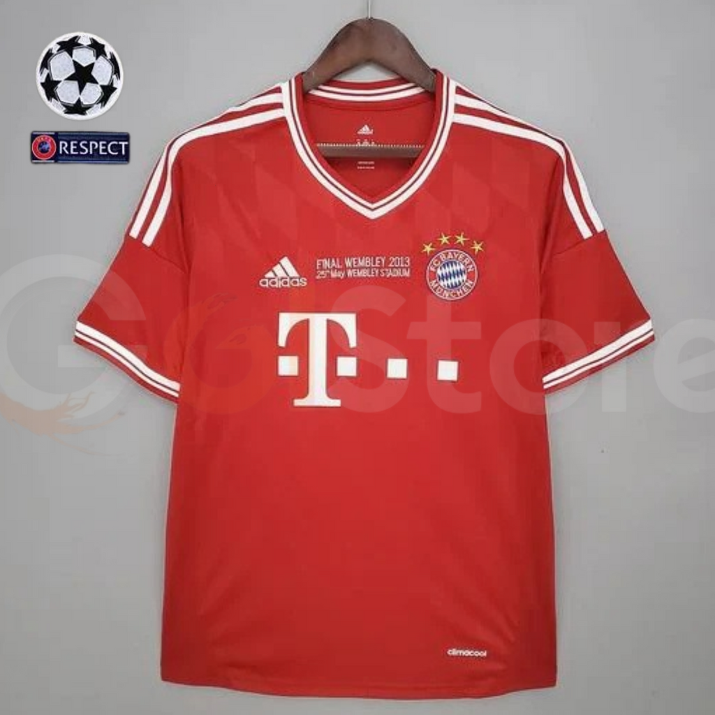 Front view of a red Bayern Munich short-sleeve jersey with white V-neck trim, white shoulder stripes, club crest and “Final Wembley 2013” chest lettering.