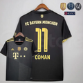 Front and back views of a black Bayern Munich short-sleeve away jersey with gold details, dotted diagonal front patterns and Coman 11 printing on the back.