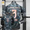 Bayern Munich 2024–2025 short-sleeve away jersey, front and back views, with a dark grey pattern, black panels and copper-coloured MINJAE number 3 printing.