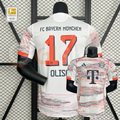 Front and back views of a white Bayern Munich short-sleeve jersey with red and grey patterns, orange trim, and Olise 17 printing on the back.
