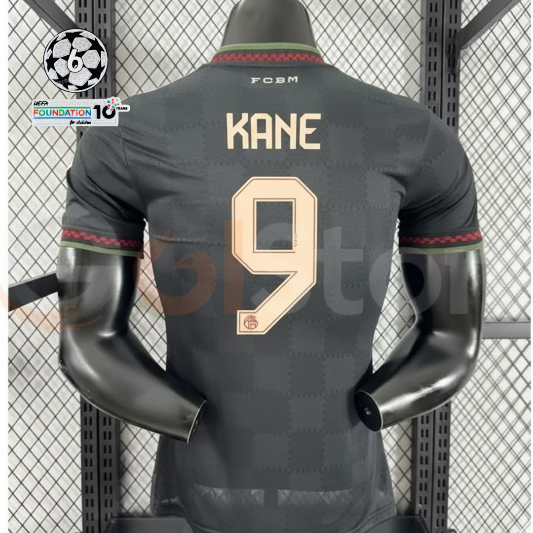 Back view of a dark grey Bayern Munich 2025–2026 short-sleeve third jersey with gold-coloured KANE number 9 printing and red and green collar and cuff trim.