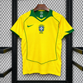 Front view of a yellow Brazil 2004 retro short-sleeve home jersey with a green V-neck, green sleeve trim and piping, and a central CBF crest.