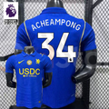 Front and back views of a blue Chelsea short-sleeve jersey with yellow details, white Acheampong number 34 print and a gold chest badge, alongside a Premier League graphic.