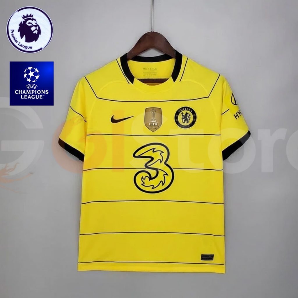  Front view of a yellow Chelsea FC 2021–2022 short-sleeve away jersey with thin black horizontal stripes, black collar and sleeve trim, and a gold FIFA chest badge.