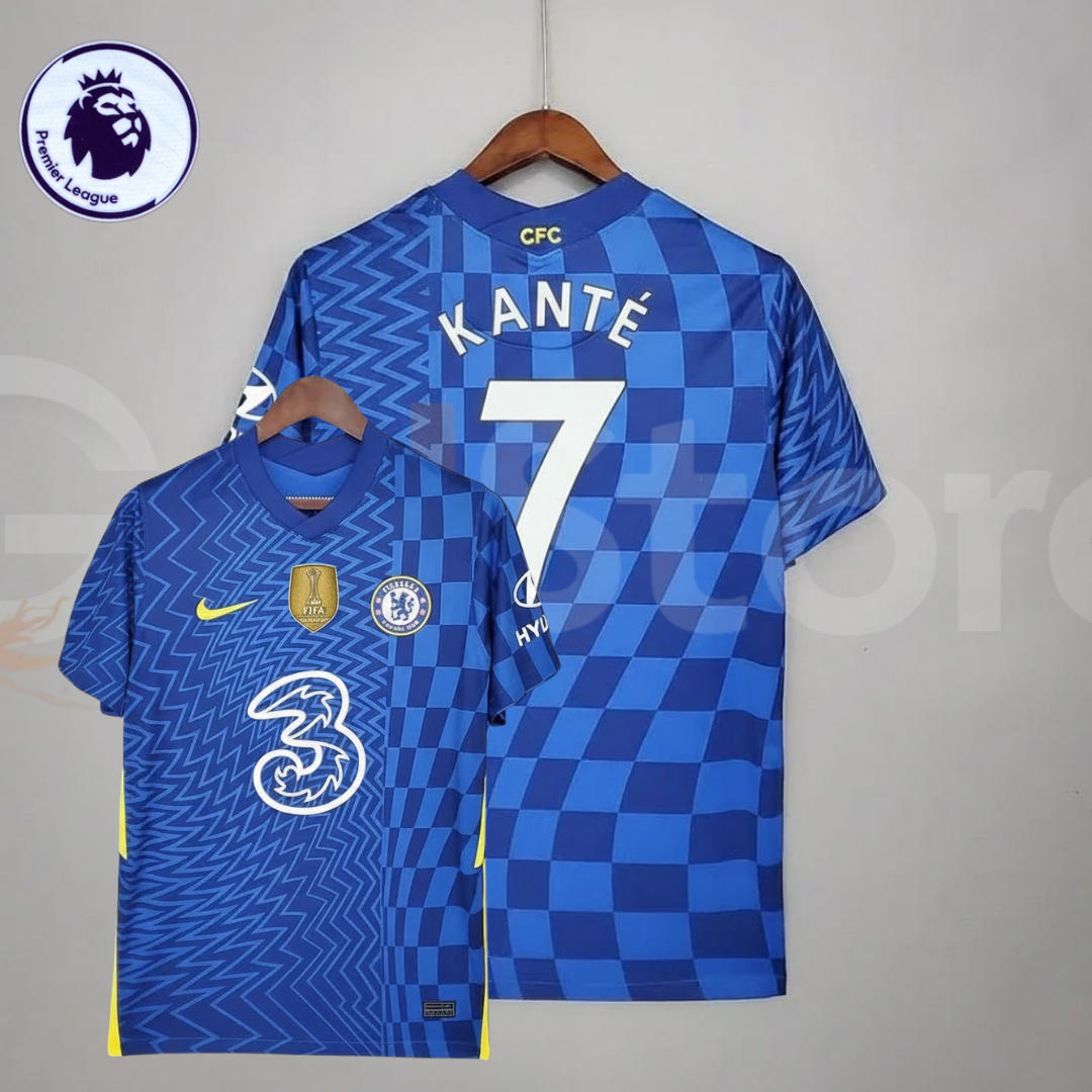 Front and back views of a blue Chelsea FC 2021–2022 short-sleeve home jersey with white Kanté #7 printing, zigzag and checkerboard patterns, yellow accents and a gold FIFA chest badge.