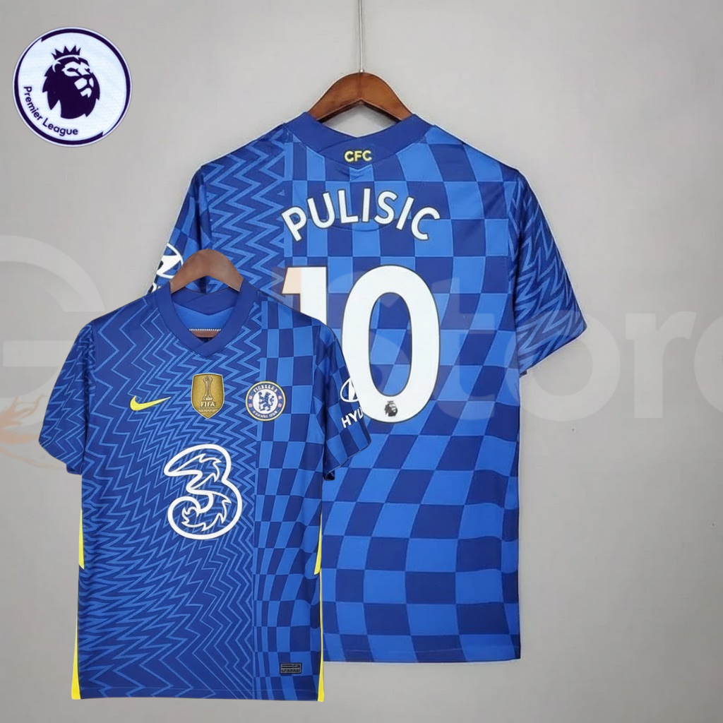 Front and back views of a blue Chelsea FC 2021–2022 short-sleeve home jersey with white Pulisic #10 printing, zigzag and checkerboard patterns, yellow accents and a gold FIFA chest badge.