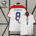 Front and back views of a white England short-sleeve retro jersey with red shoulder panels, dark blue Scholes number 8 print and sleeve patches, alongside a EURO 2004 graphic.