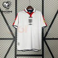  Front view of a white England short-sleeve retro home jersey with a polo collar, red shoulder panels, dark trim and a central Three Lions crest, alongside a EURO 2004 graphic.