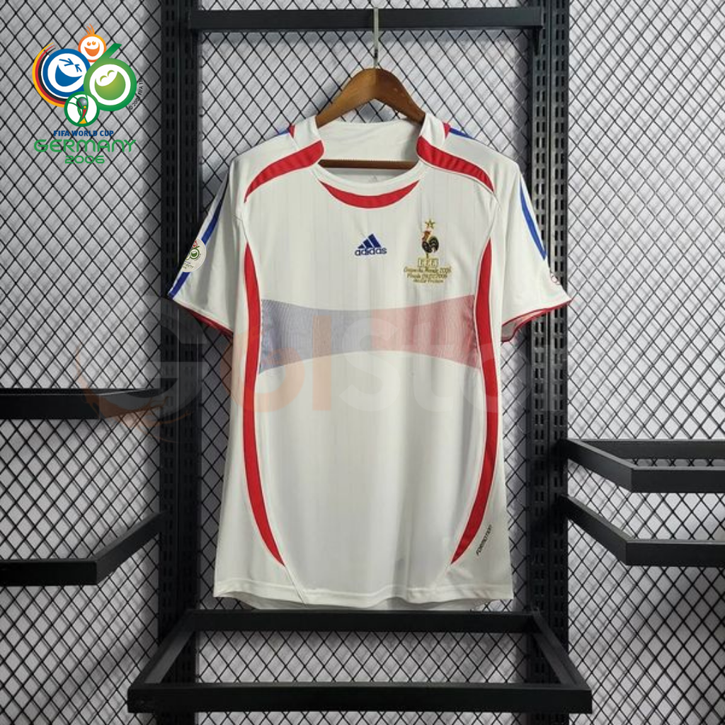 Front view of a France 2006 retro white short-sleeve away jersey with red and blue detailing, national team crest and a World Cup sleeve patch.