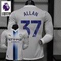 Front and back views of a white Manchester City long-sleeve jersey with blue central stripes and Allan number 37 print, alongside a Premier League graphic.