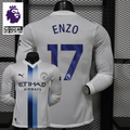 Front and back views of a white Manchester City long-sleeve jersey with blue central stripes and Enzo number 17 print, alongside a Premier League graphic.