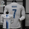  Front and back views of a white Manchester City long-sleeve jersey with blue central stripes, blue Ndiaye number 7 print and Etihad Airways sponsor, alongside UCL graphics.