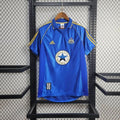 Front view of a blue Newcastle United retro short-sleeve away jersey with yellow shoulder stripes, a polo collar, club crest and circular Newcastle Brown Ale sponsor.