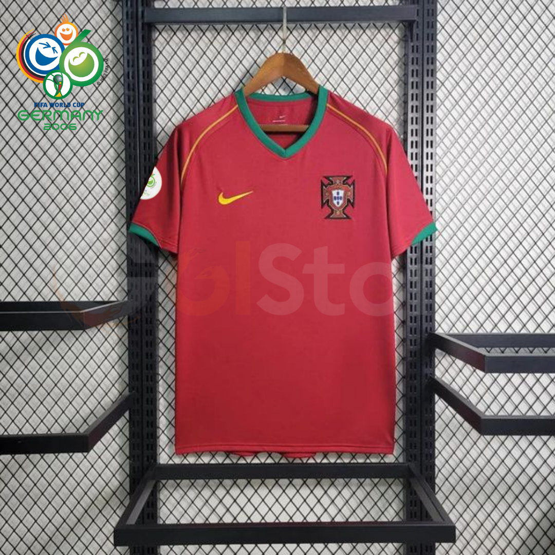 Front view of a Portugal 2006 retro red short-sleeve home jersey with green collar and sleeve trim, gold detailing, national team crest and a World Cup sleeve patch.