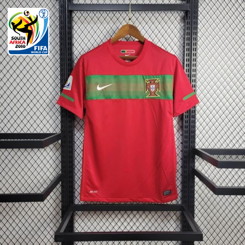 Front view of a red Portugal 2010 retro short-sleeve home jersey with a green chest band, Portugal crest and World Cup sleeve patch.