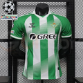 Real Betis green and white striped short-sleeve jersey with diagonal line details, a white collar, GREE sponsor and Champions League and UEFA Foundation sleeve patches.
