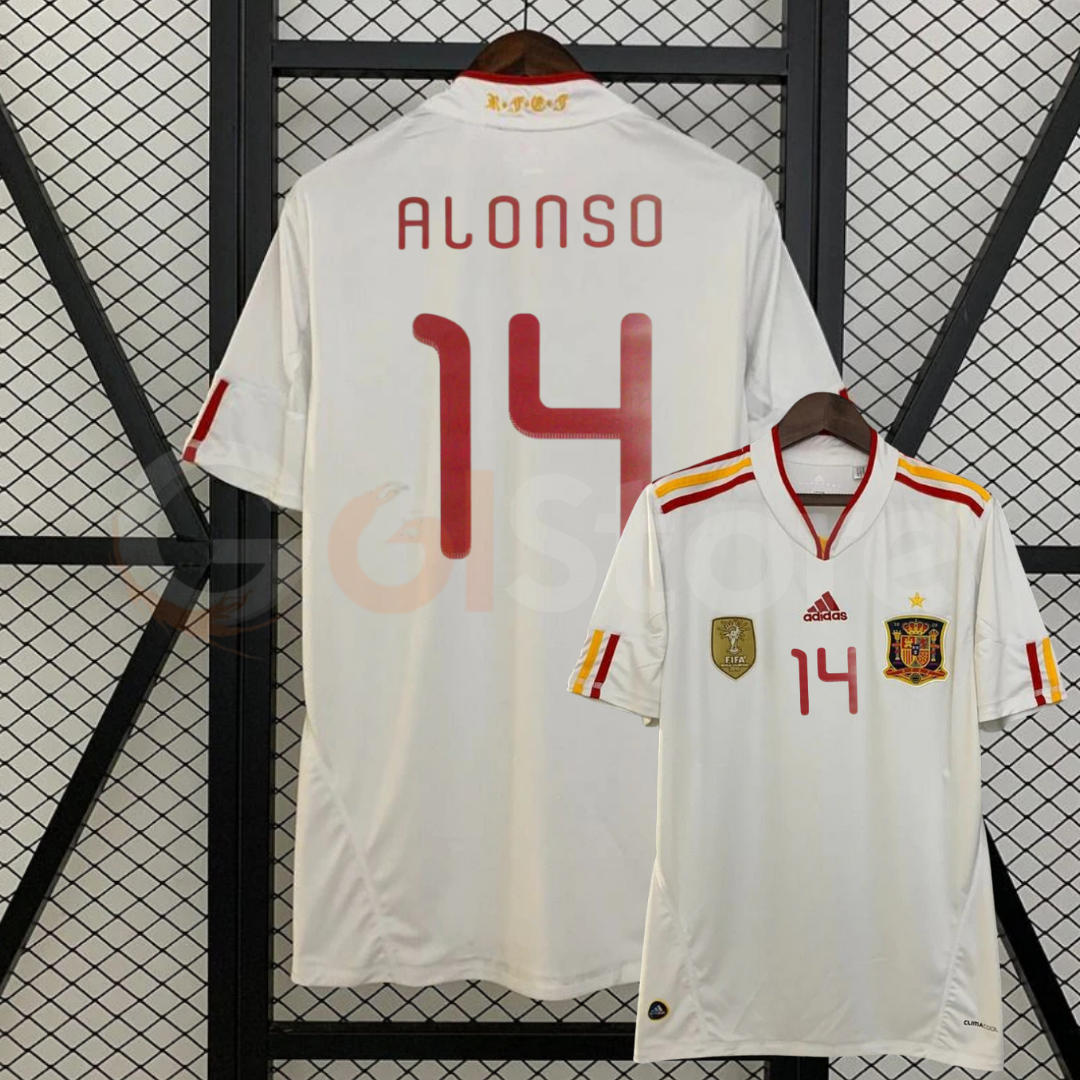 Spain white short-sleeve retro jersey shown from the front and back, with red ALONSO 14 print, red and yellow shoulder stripes and a gold FIFA World Champions chest badge.
