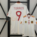 Spain white short-sleeve retro jersey shown from the front and back, with red TORRES 9 print, red and yellow shoulder stripes and a gold FIFA World Champions chest badge.
