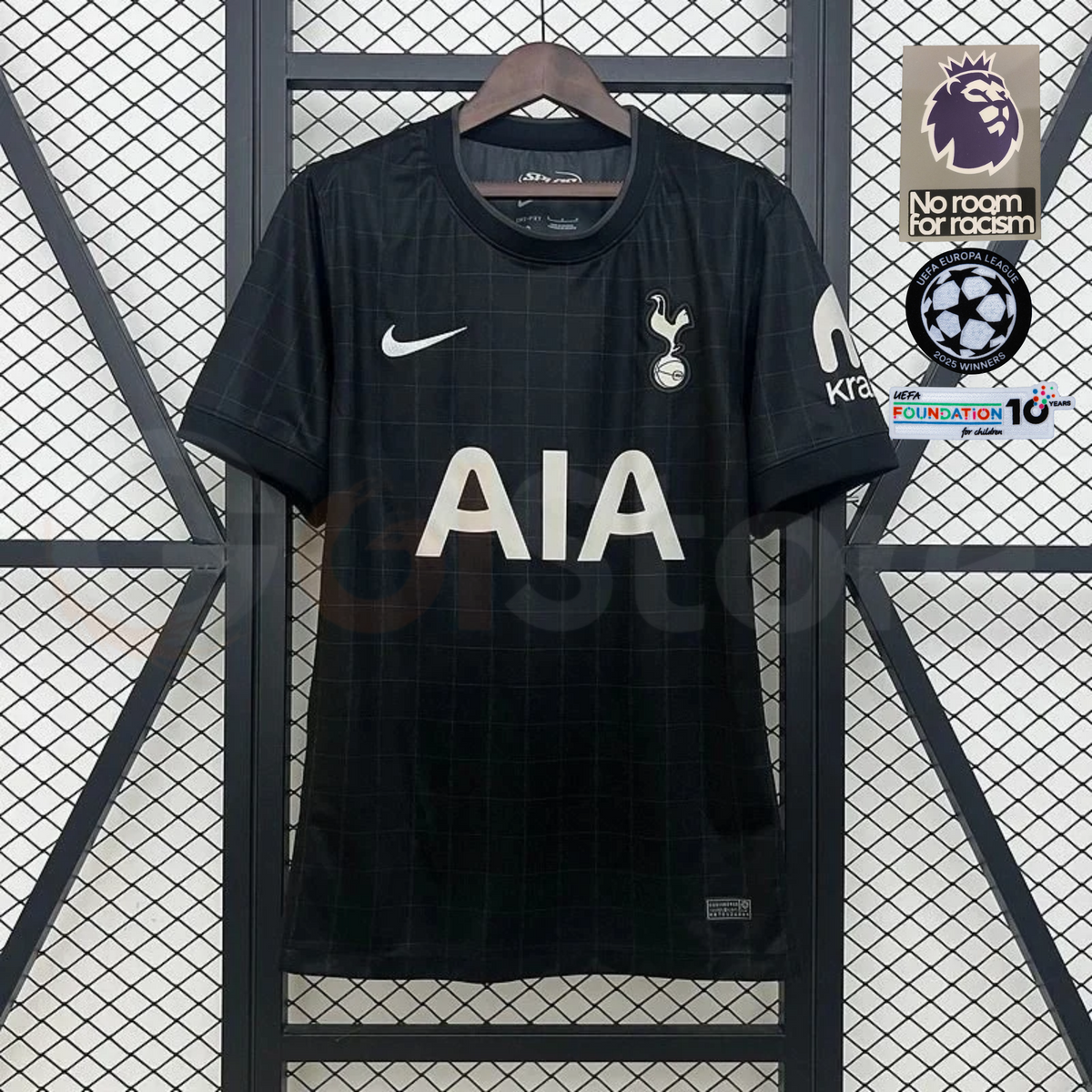  Front view of a black Tottenham Hotspur short-sleeve fan jersey with a subtle grid pattern, white AIA sponsor, club crest and white sleeve sponsor.