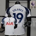 Front and back views of a white Tottenham Hotspur short-sleeve home jersey with navy and grey sleeves, navy Solanke number 19 print and red AIA sponsor.